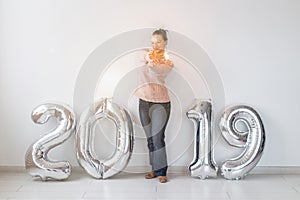 Party, holidays and people concept - Happy young woman celebrating New Year with big 2019 symbol and sparklers