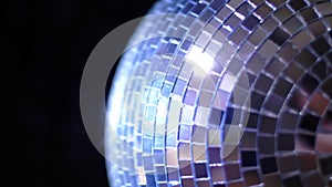 Party Light music disco ball changing hue on black background. Rotating sparkling mirror disco ball rotating in nightclub lights,