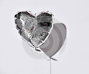 Party is over deflated silver heart balloon object  on white gray background with shadow