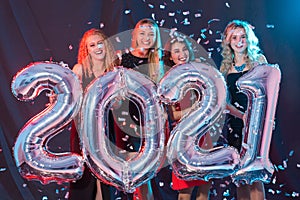 Party, people and new year holidays concept - cheerful young women celebrating new years eve 2021