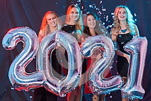 Party, people and new year holidays concept - cheerful young women celebrating new years eve 2021