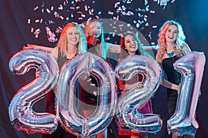 Party, people and new year holidays concept - cheerful young women celebrating new years eve 2021