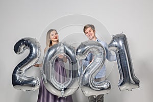 Party, people and new year holidays concept - woman and man celebrating new years eve 2021