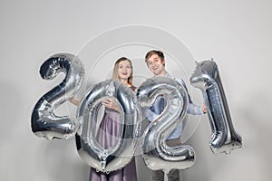 Party, people and new year holidays concept - woman and man celebrating new years eve 2021