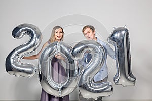 Party, people and new year holidays concept - woman and man celebrating new years eve 2021