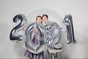 Party, people and new year holidays concept - woman and man celebrating new years eve 2021