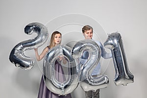 Party, people and new year holidays concept - woman and man celebrating new years eve 2021
