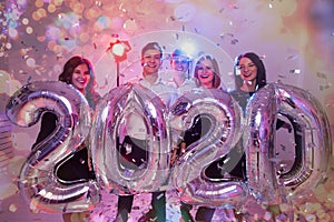 Party, people and new year holidays concept - women and men celebrating new years eve 2020