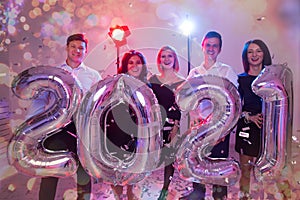 Party, people and new year holidays concept - women and men celebrating new years eve 2021