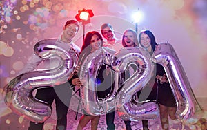 Party, people and new year holidays concept - women and men celebrating new years eve 2021