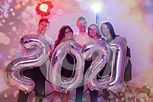 Party, people and new year holidays concept - women and men celebrating new years eve 2021