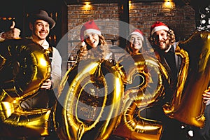 Party, people and new year holidays concept - women and men celebrating new years eve 2021.