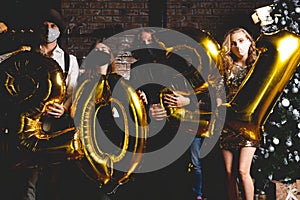 Party, people and new year holidays concept - women and men in protective medical mask celebrating new years eve 2021