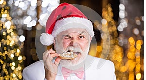 Party souvenir. man eat christmas cookie. happy man with cookies gift. santa businessman food present illuminated