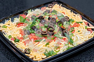 Party Taco Layer Dip. Zesty cream cheese and sour cream topped with lettuce, diced tomatoes, sliced olives, green onions