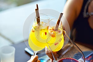 Party toasting in restaurant, Close up of three hands raising cocktail glasses