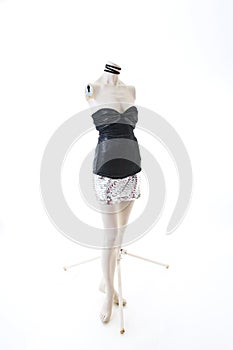 Party top black and silver with mini mirror skirt on mannequin full body shop display. Woman fashion styles, clothes on white stud