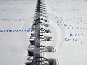 Pascal program written in a notebook. side view. the work of the programmer and sisadmida