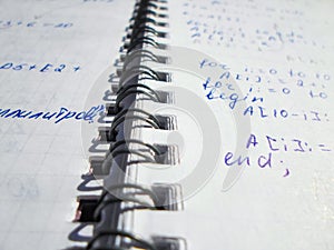 Pascal program written in a notebook. side view. the work of the programmer and sisadmida