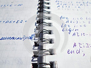 Pascal program written in a notebook. side view. the work of the programmer and sisadmida