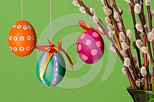 Paschal eggs on willow bouquet, horizontal over green