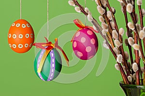 Paschal eggs on willow bouquet, horizontal over green photo