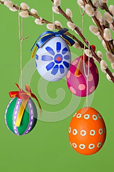 Paschal eggs on willow bouquet, vertical over green