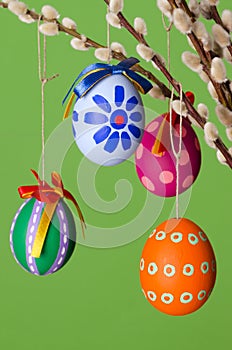 Paschal eggs on willow bouquet, vertical over green photo