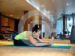 Pashchimottanasana, longevity pose. Stylish modern middle aged woman stretching