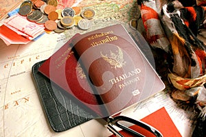 Pasport with the symbols of Thailand and Republique francaise and some coins on world map. photo