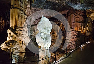 Passage for tourists with big stalactites and stalagmites in Postojna cave, Slovenia, Europe