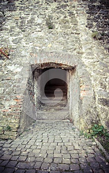 Passage between two parts of the ancient castle with an old stone staircase. Stone arch and steps in the castle. Stone corridor