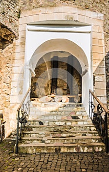 Passage between two parts of the ancient castle with an old stone staircase. Stone arch and steps in the castle. Stone corridor