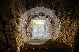 Passage between two parts of the ancient castle with an old stone staircase. Stone arch and steps in the castle. Stone corridor