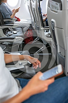 Passangers in abord a commercial flight using their cell phones photo