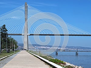 Walking the footpath Passeio do Tejo along Tagus river in Lisbon at the Expo park - Vasco da Gama bridge photo
