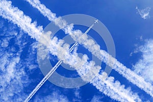 a passenger aircraft with contrails in the blue sky crosses other