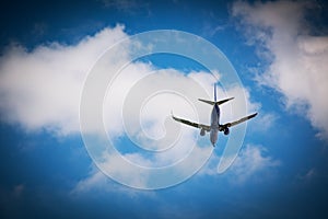 Passenger aircraft flying in the blue sky with white clouds.