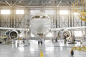 Passenger aircraft on maintenance of engine-disassembled engine blades and fuselage repair in airport hangar.