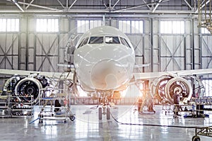 Passenger aircraft on maintenance of engine and fuselage repair in airport hangar.