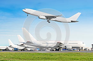 Passenger aircraft row, airplane parked on service before departure at the airport, other plane push back tow. One two-story airpl