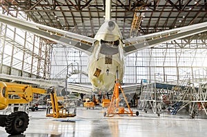 Passenger aircraft on service in an aviation hangar rear view of the tail, on the auxiliary power unit.