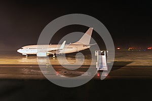 Passenger airplane on airport runway - night shot photo