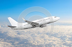 Passenger airplane fly on a hight above overcast clouds and blue sky.