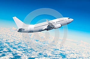 Passenger airplane fly on a hight above overcast clouds and blue sky.