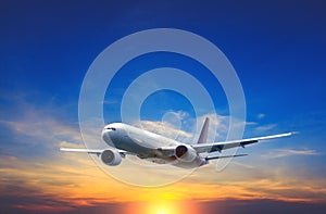 Passenger airplane flying above night clouds and amazing sky at the sunset.