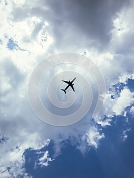 Passenger airplane flying in blue cloud sky