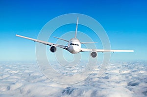 Passenger airplane flying at flight level high in the sky above the clouds. View directly in front, exactly.