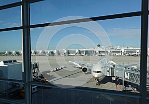 Passenger airplane landed in Munich international airport view through panoramic toned airport window on sunny day