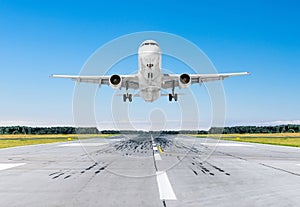 Passenger airplane landing at in good clear weather with a blue sky on a runway.